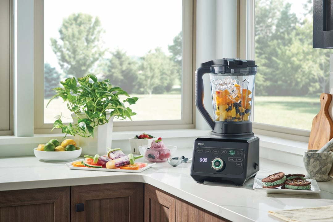 Braun PowerBlend 9 Jug Blender on a kitchen counter with fruit and desserts