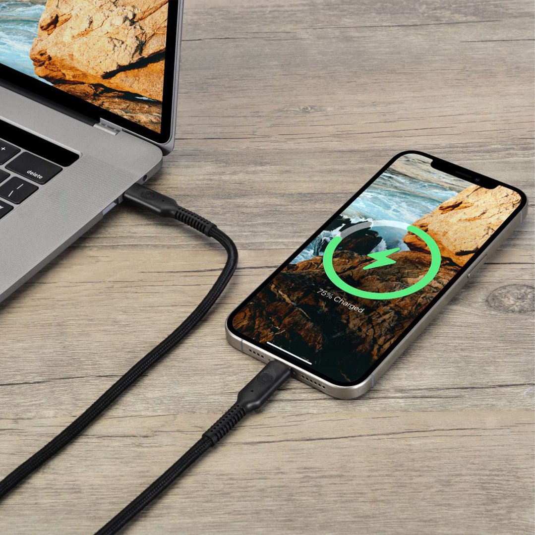 USB-C cable connecting a laptop and a smartphone on a wooden surface