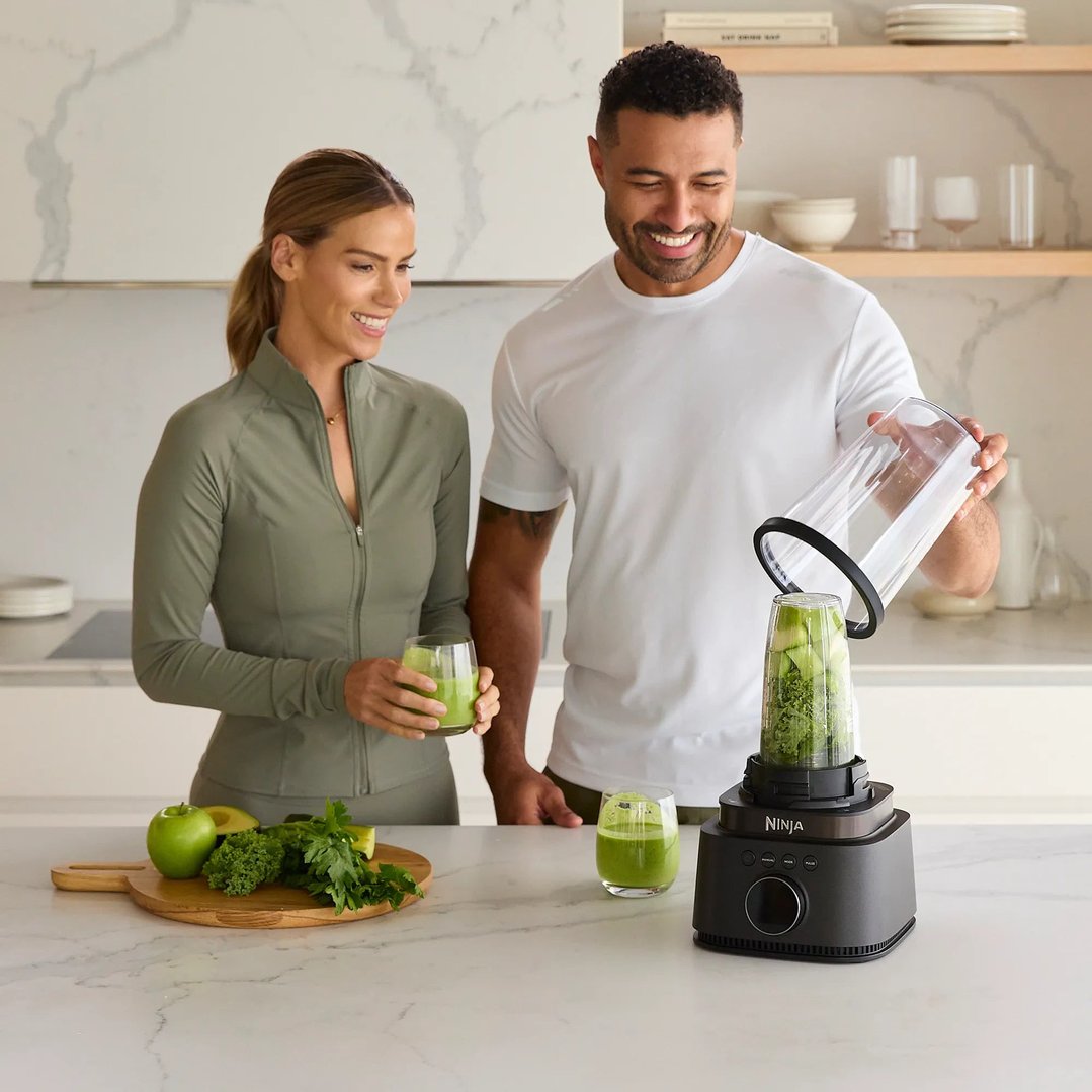 Man and woman preparing green smoothies with a Ninja blender