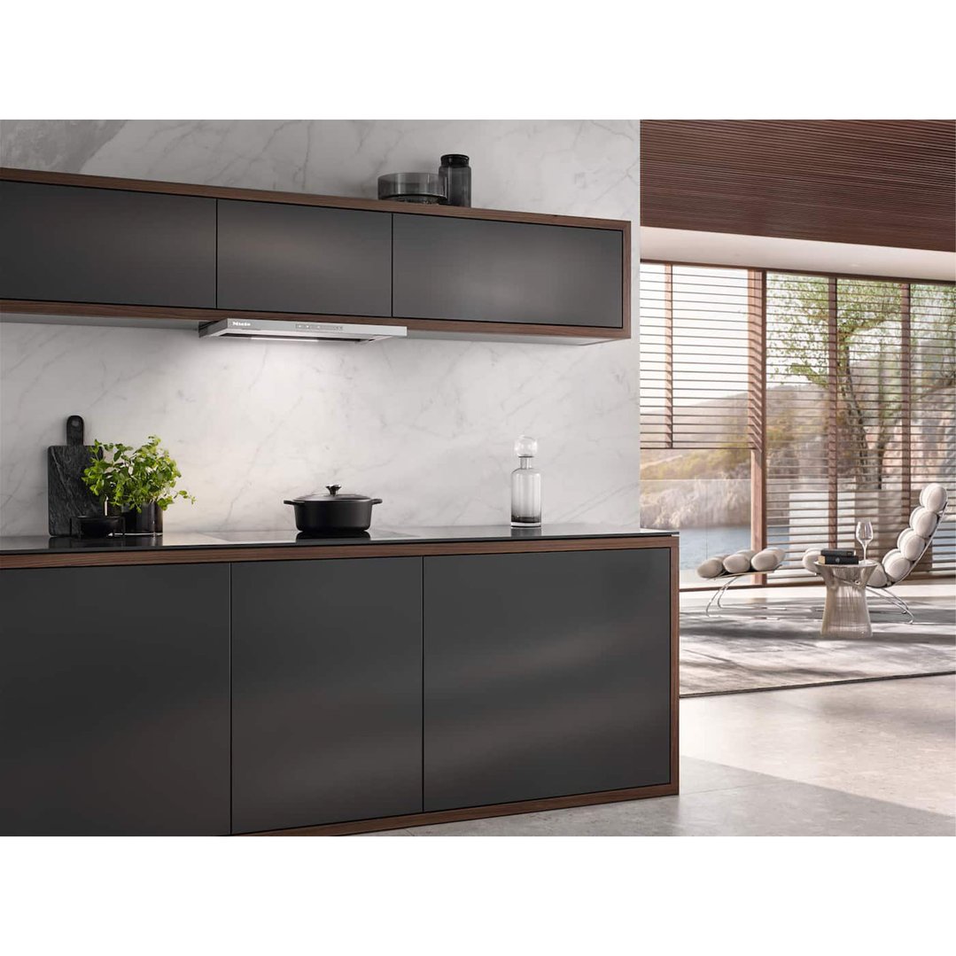 A Miele rangehood installed above a cooktop in a modern kitchen with a view