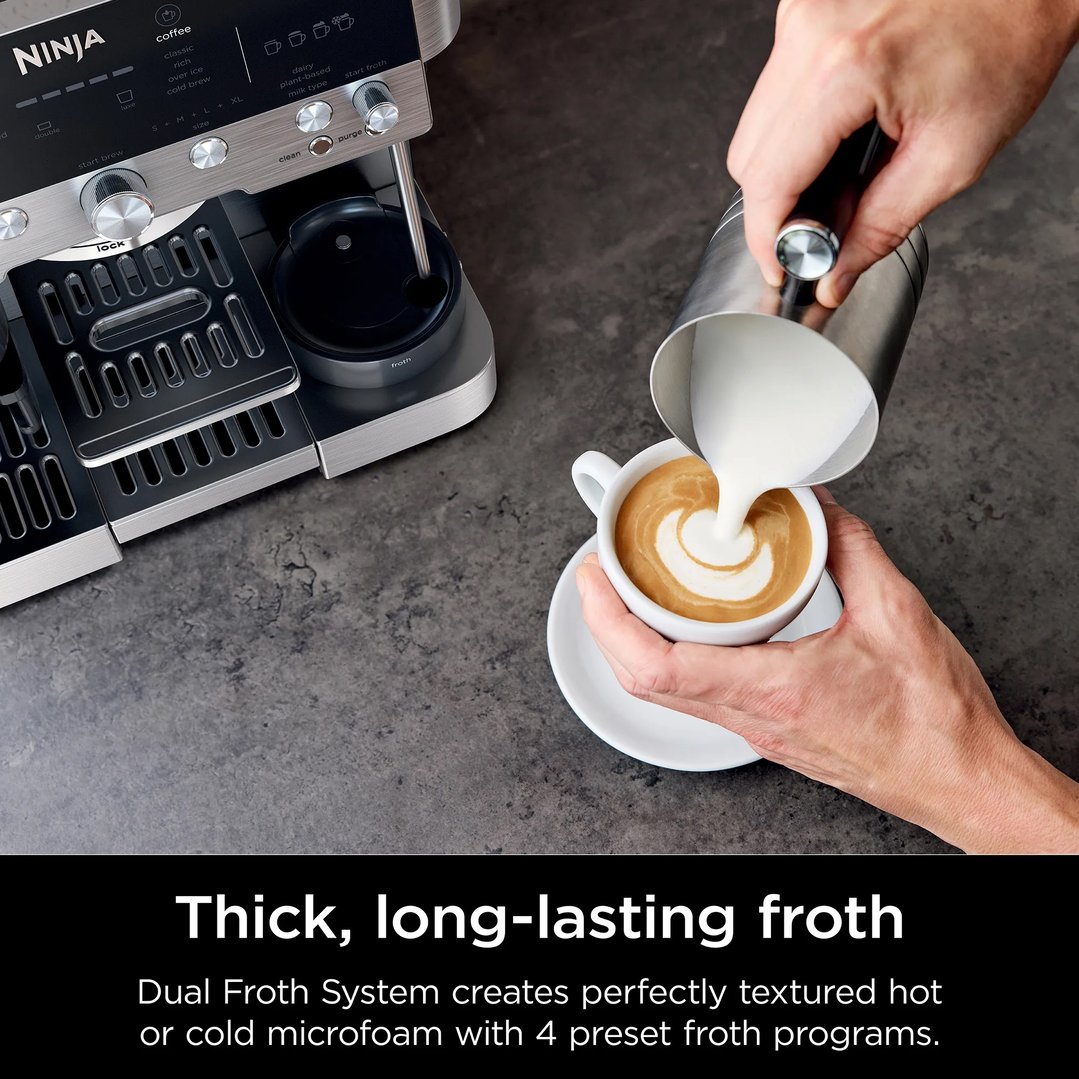Hand pouring frothed milk into a cup of coffee from a coffee machine
