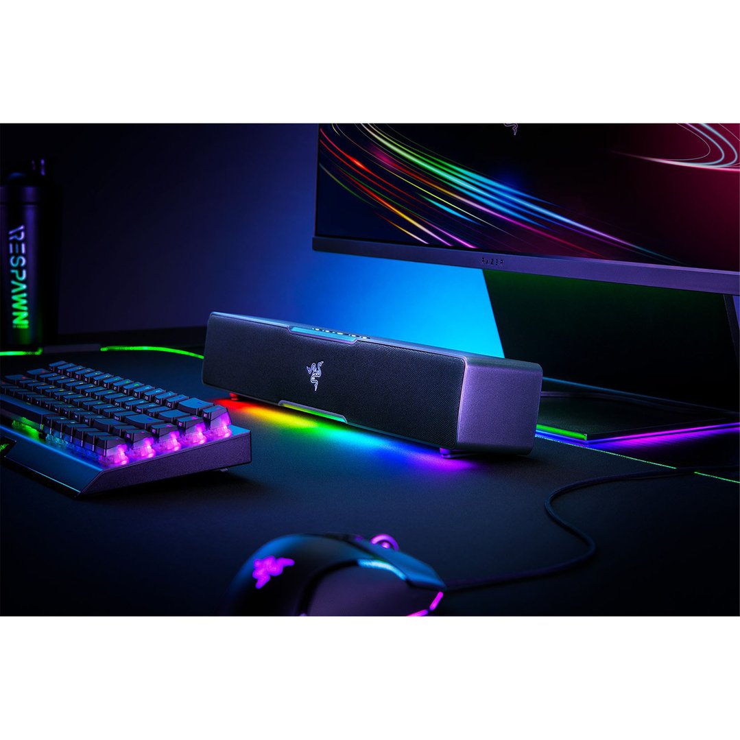 Gaming soundbar, keyboard, and mouse on a desk with colorful lighting