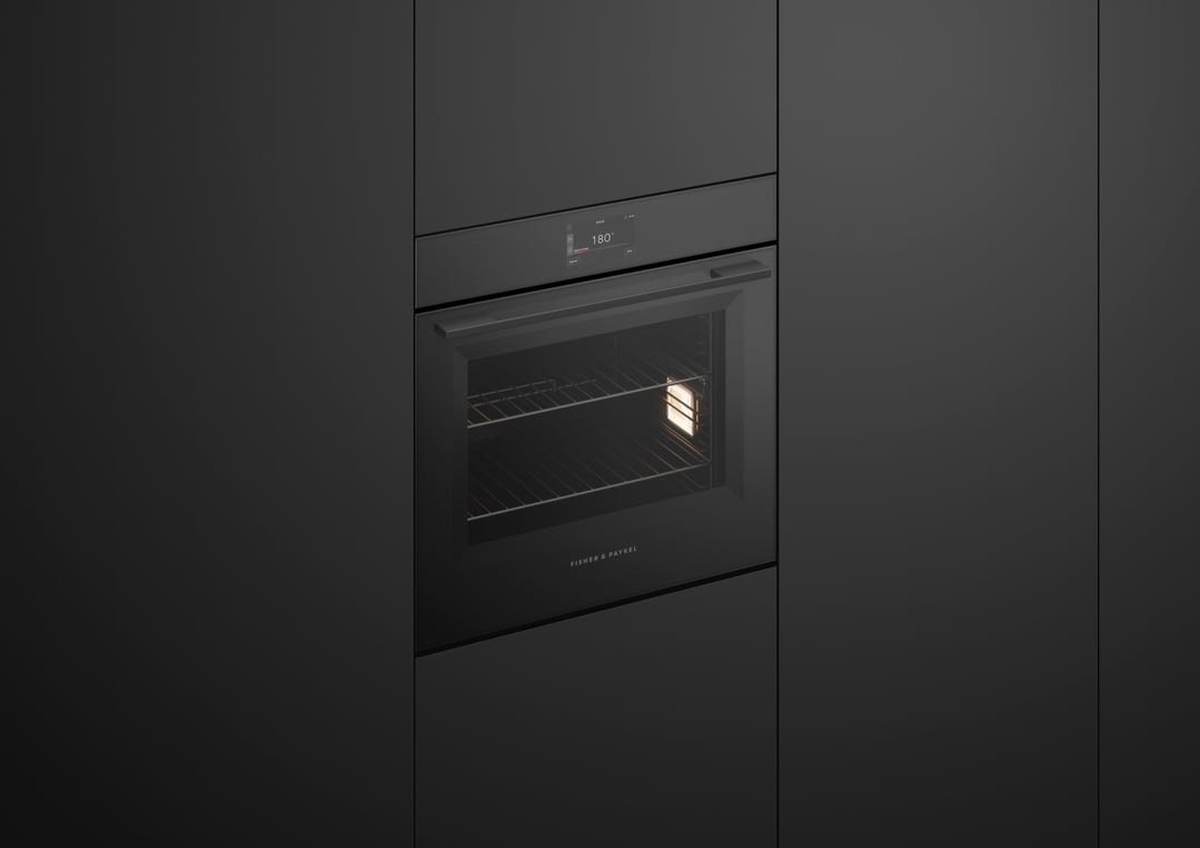 Built-in black oven with a digital display showing 180 degrees in a dark kitchen