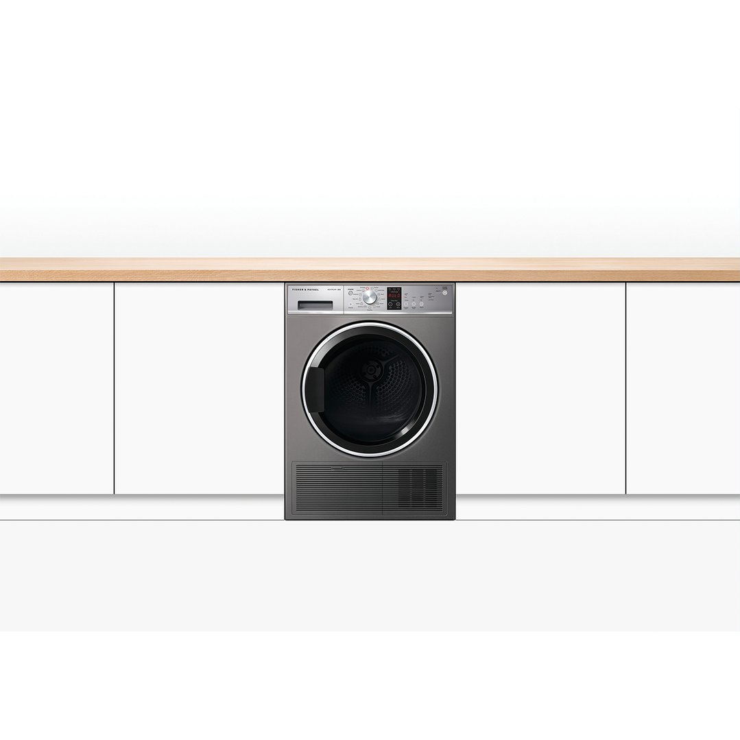 Heat pump dryer integrated into white cabinetry with a wooden countertop