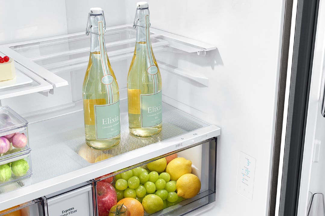 Open French door fridge interior with drinks, fruits, and vegetables