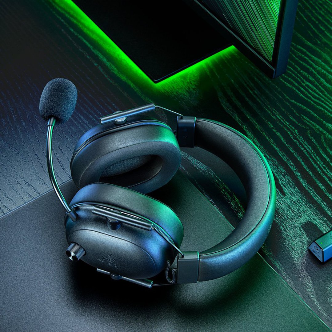Black Razer headset with microphone on a dark desk with green lighting