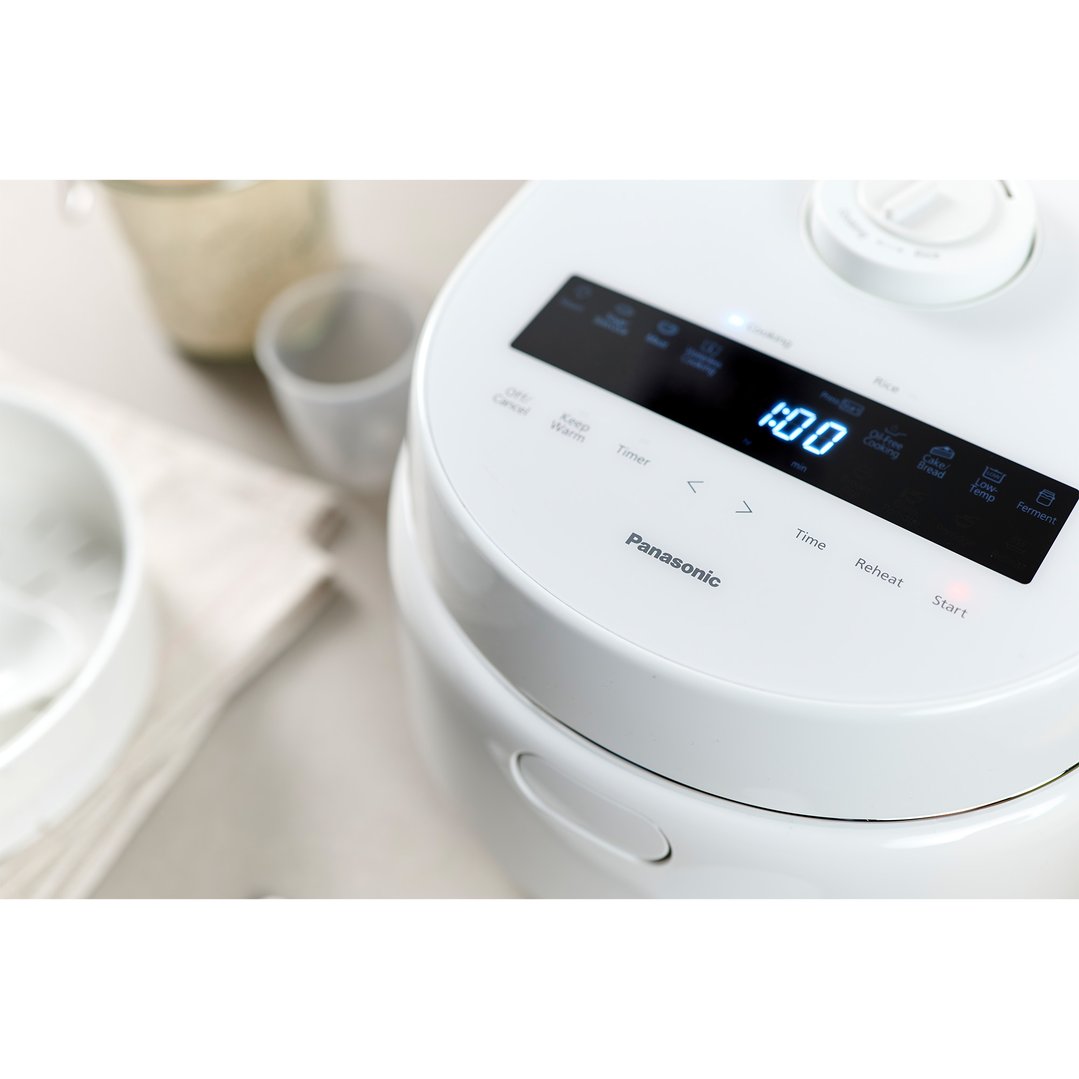 Close-up of a Panasonic rice cooker with its digital display showing 1:00