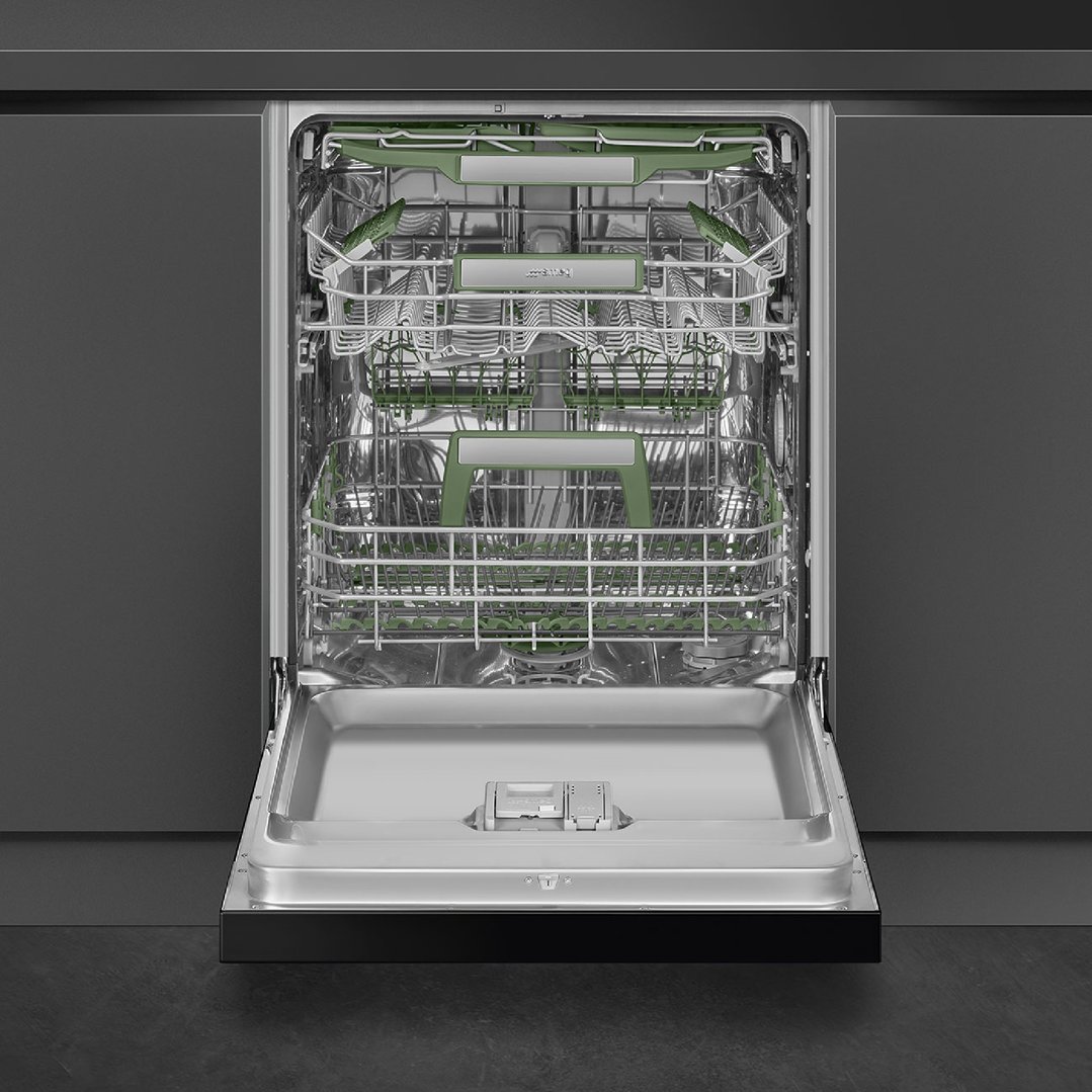 Open dishwasher with green racks in a dark kitchen setting