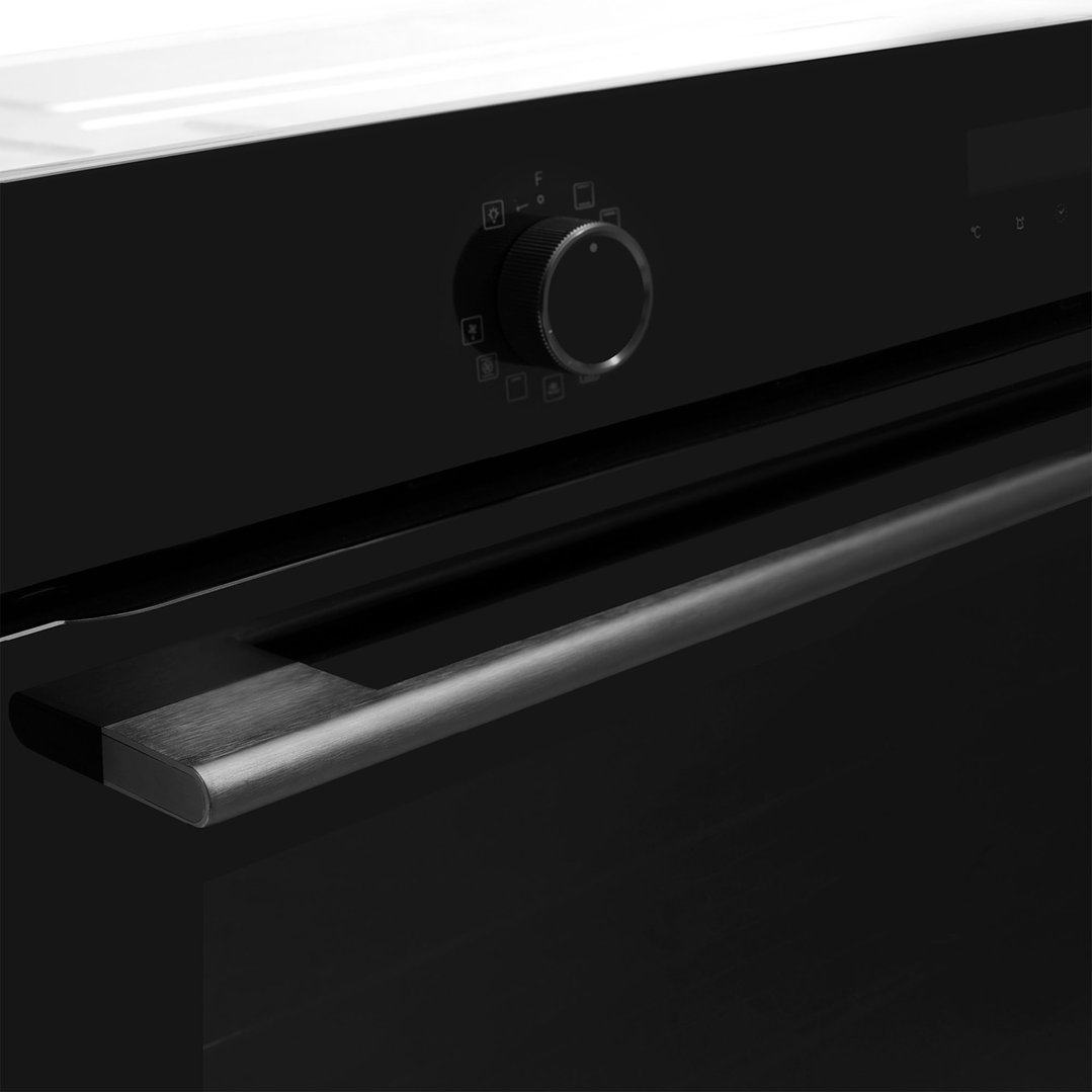 Close up of an oven with a control knob and handle