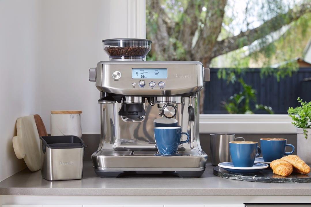 Breville Barista Pro coffee machine on a kitchen counter with coffee and croissants