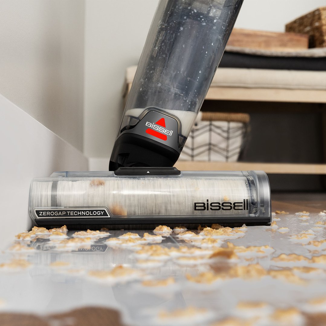 Bissell vacuum cleaner cleaning spilled cereal and milk on a hard floor