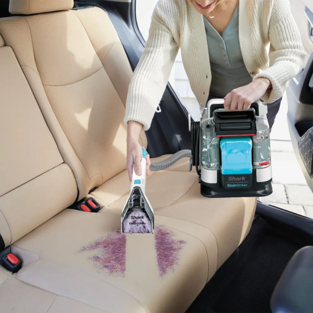Woman cleaning a stain from a car seat with a SHARK cleaningAccessories