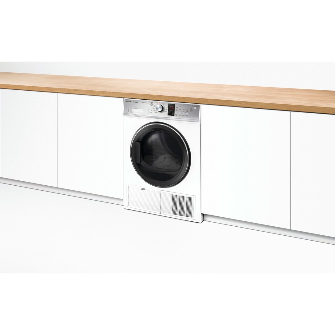 Fisher & Paykel dryer built into white cabinetry with a wooden countertop