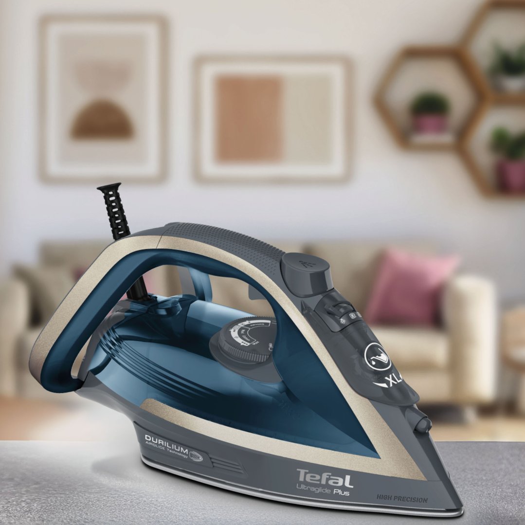 Tefal UltraGlide Plus steam iron on a grey surface in a living room