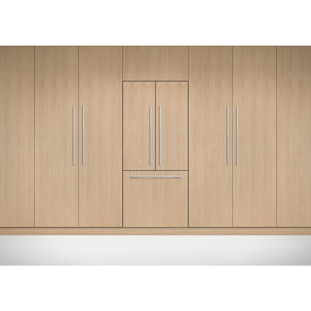 Integrated French door refrigerator built into light wood cabinetry in a kitchen