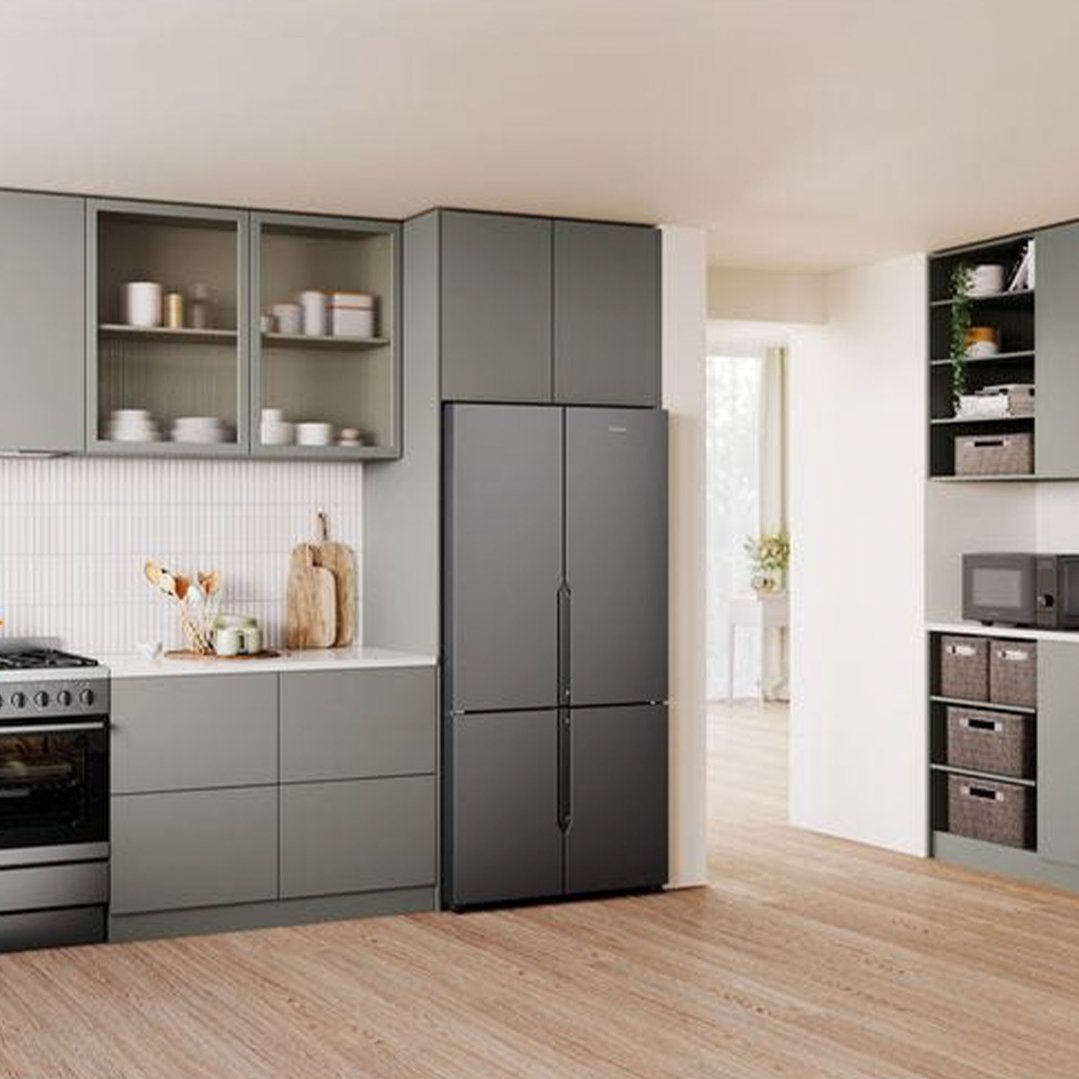 Matte charcoal black quad door fridge in a modern kitchen with light green cabinets