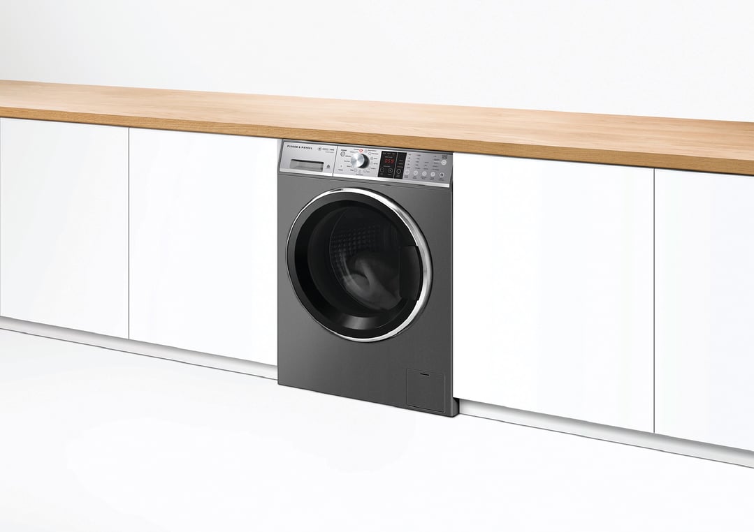Dark grey Fisher & Paykel washing machine built into white cabinetry with wooden top