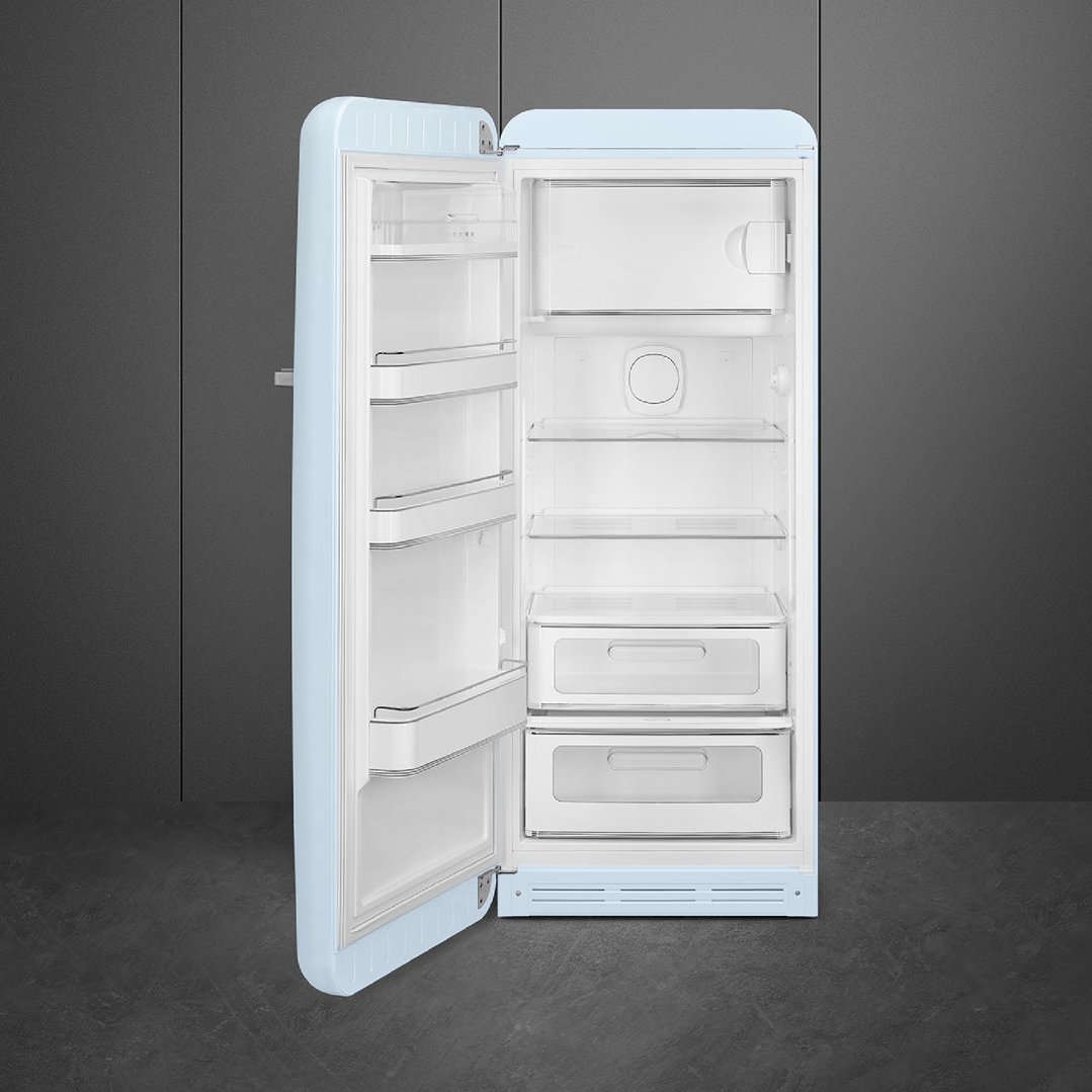Open pastel blue retro refrigerator with interior shelves and drawers against a dark wall