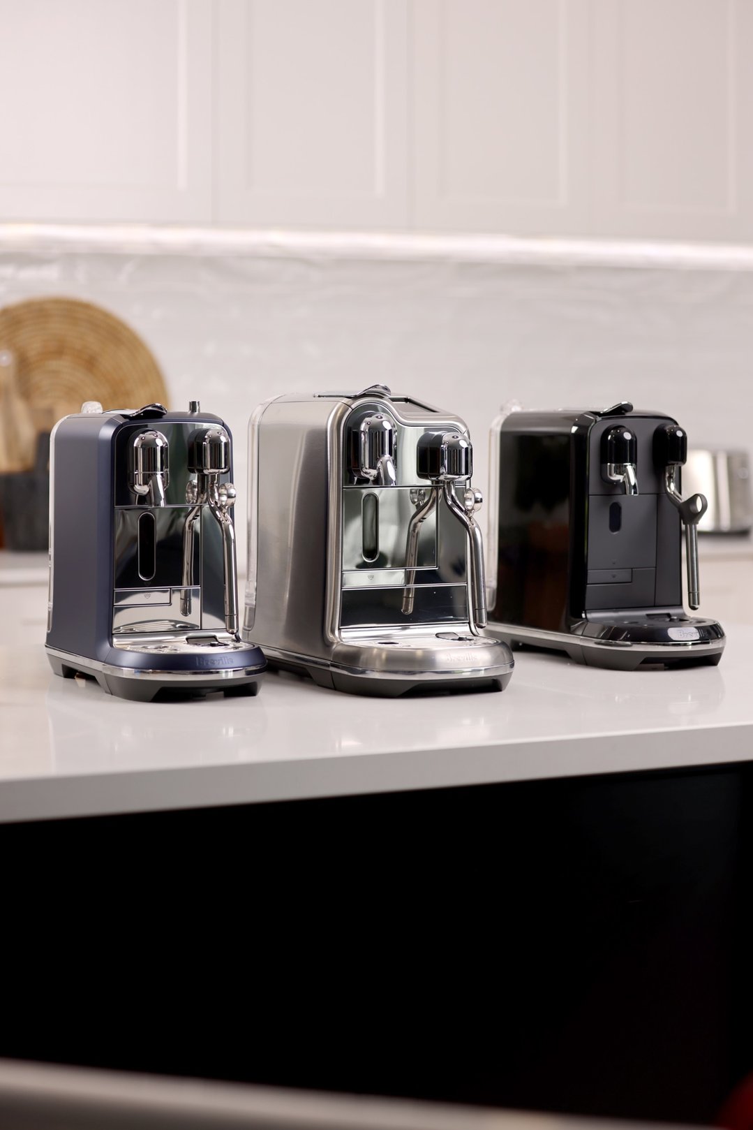 Three Nespresso Creatista Plus coffee machines on a kitchen counter