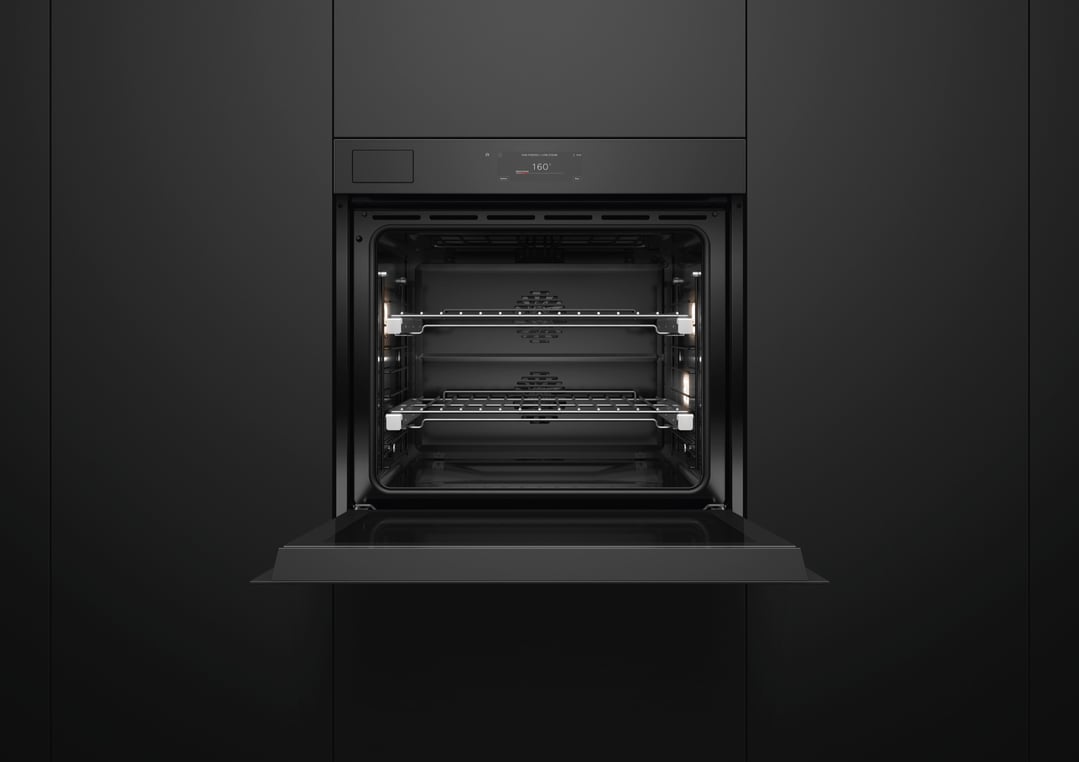 Black built-in oven with door open, showing interior racks and lights