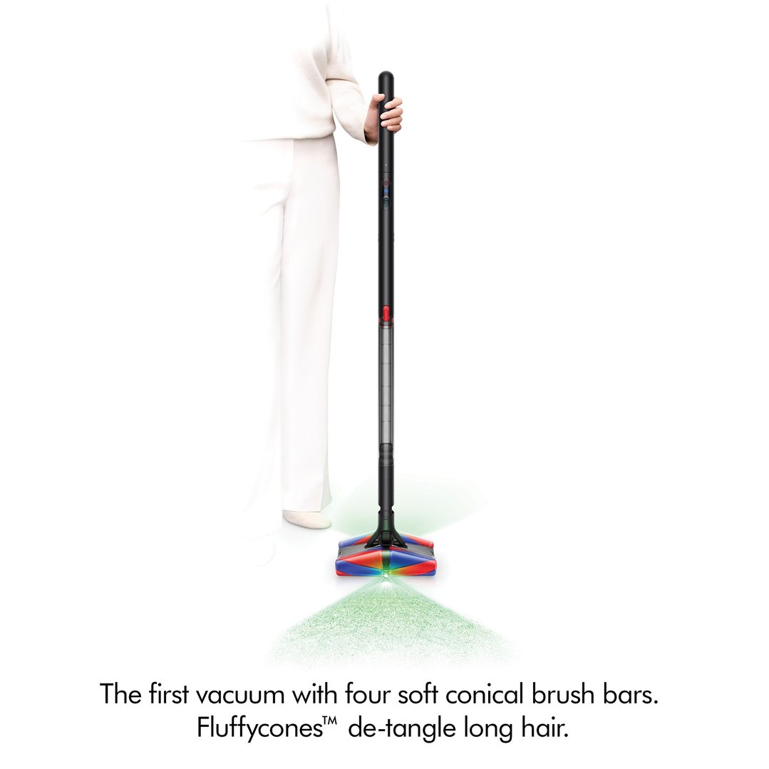 Woman holding a black handStickVacuum with green light on the floor