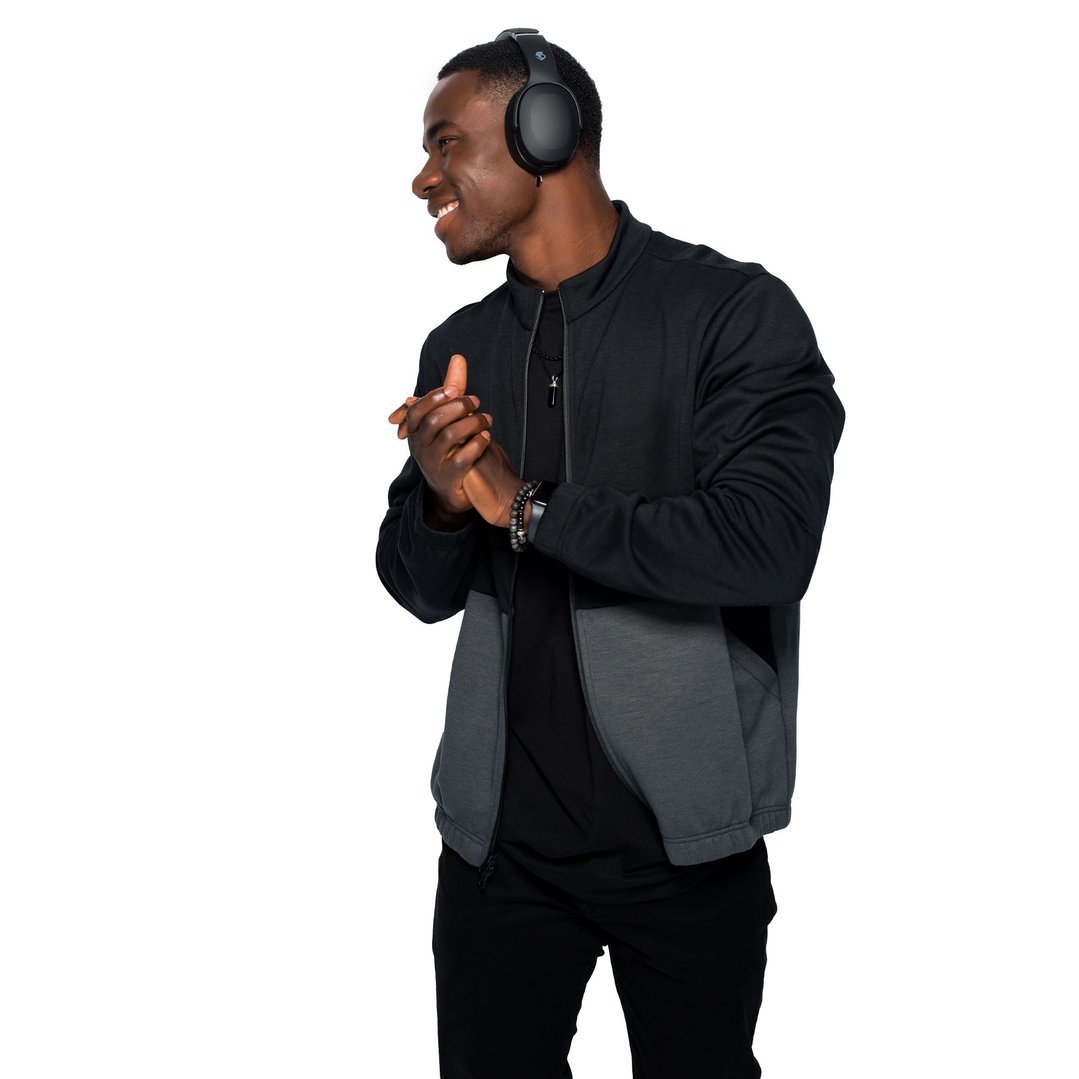 Man wearing black Skullcandy Crusher Evo headphones, smiling and clapping hands
