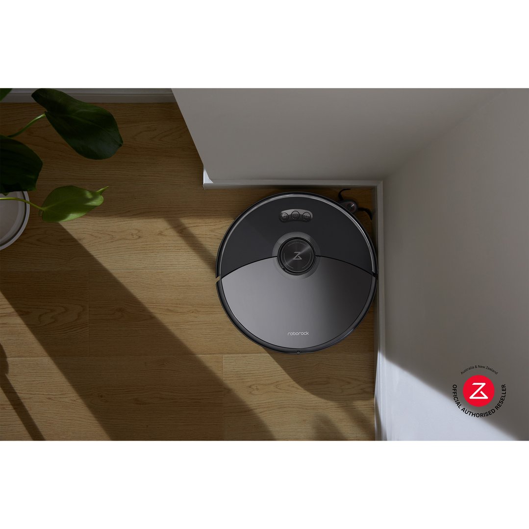 Roborock S8 MaxV Ultra robotic vacuum cleaner on a wooden floor next to a wall