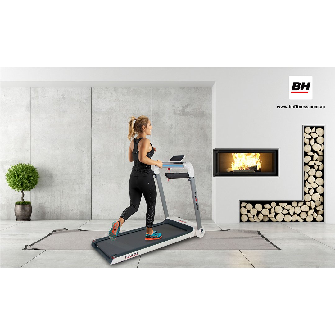 Woman running on a treadmill in a modern living room with a fireplace