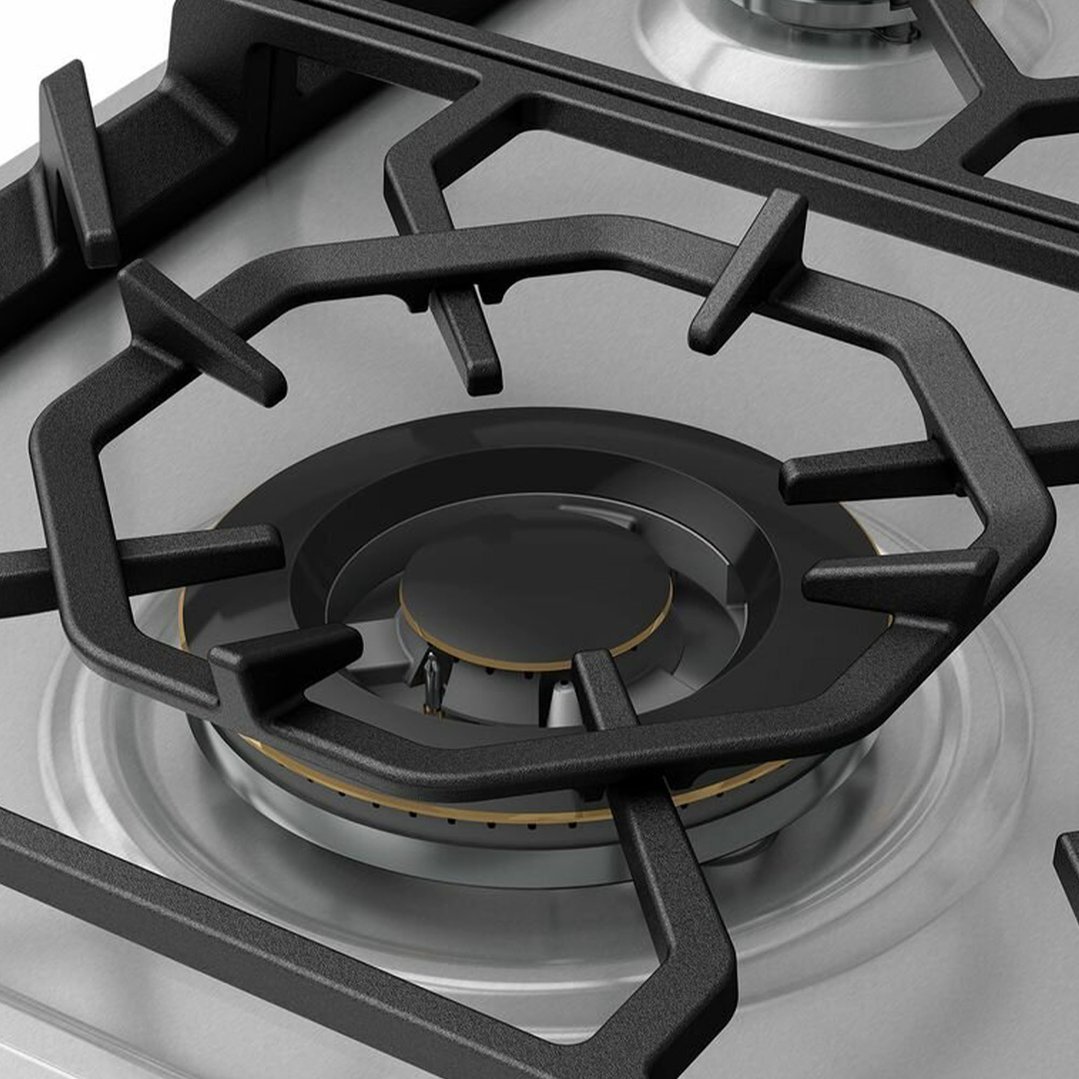 Close up of a gas cooktop burner and grates on a stainless steel surface