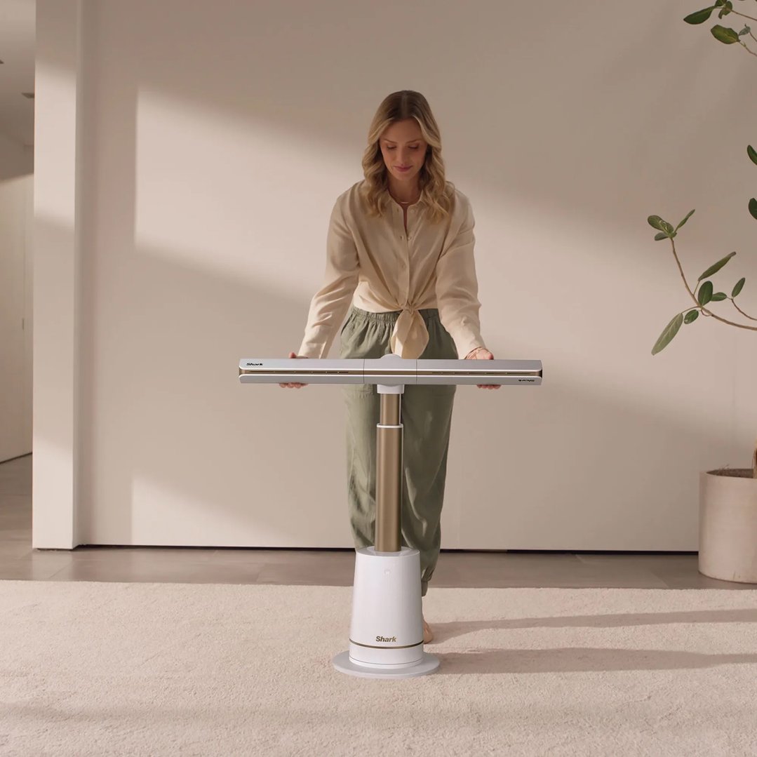 Woman holding a Shark fan in a modern living room