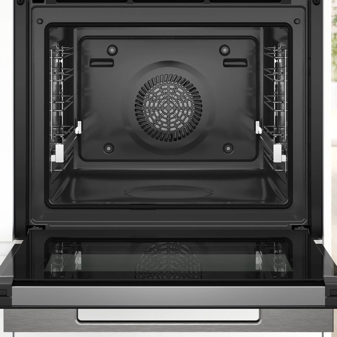 Open built-in oven with interior racks and fan visible, in a kitchen setting