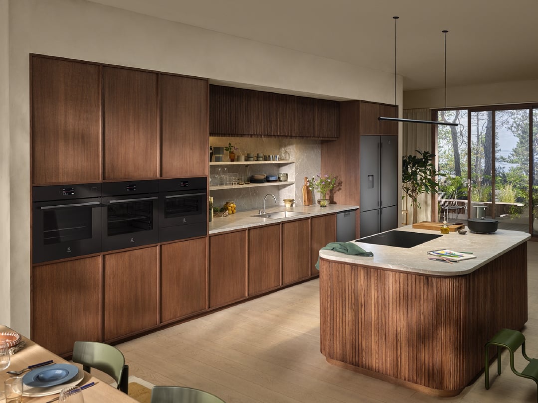 Three built-in microwave ovens in a modern kitchen with wooden cabinetry