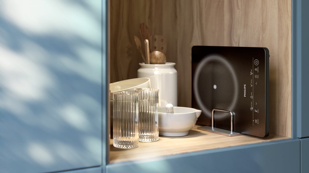 Philips induction cooker on a wooden shelf with kitchenware