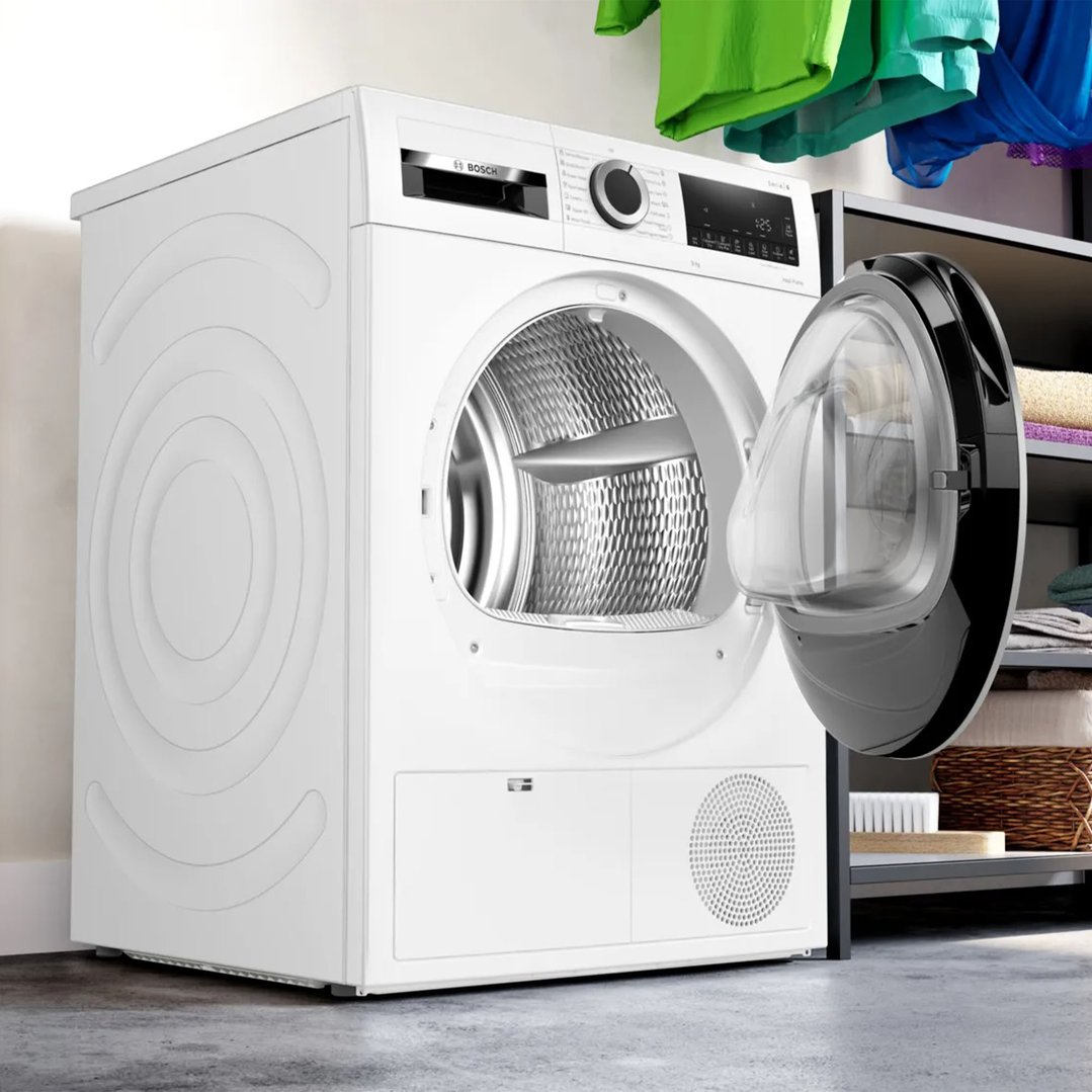 White Bosch 9kg Series 6 Heat Pump Dryer with door open in a laundry room
