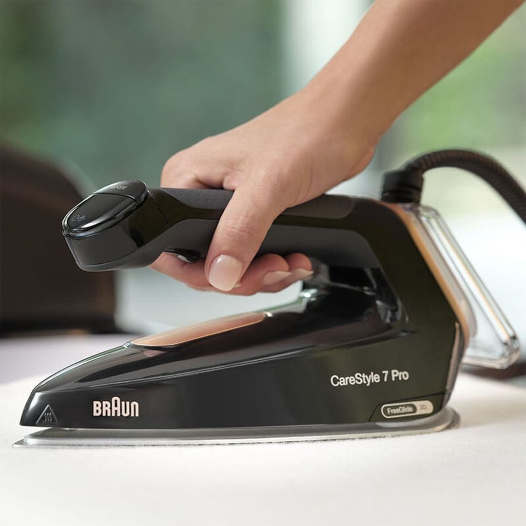 Hand holding a black Braun CareStyle 7 Pro steam generator iron