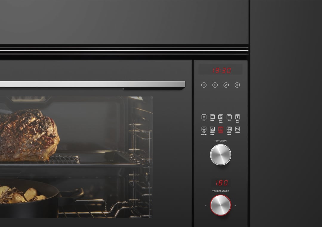 Built-in oven with a roast and potatoes cooking inside