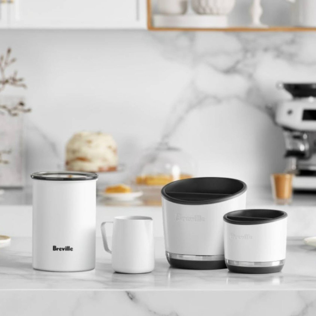 Breville coffee accessories on a white marble countertop in a kitchen