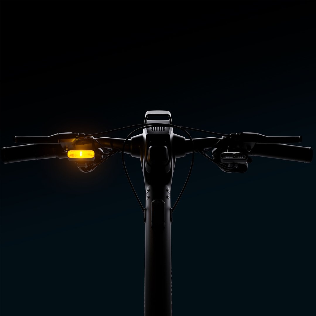 Close-up of the handlebars of an electric scooter with a glowing turn signal