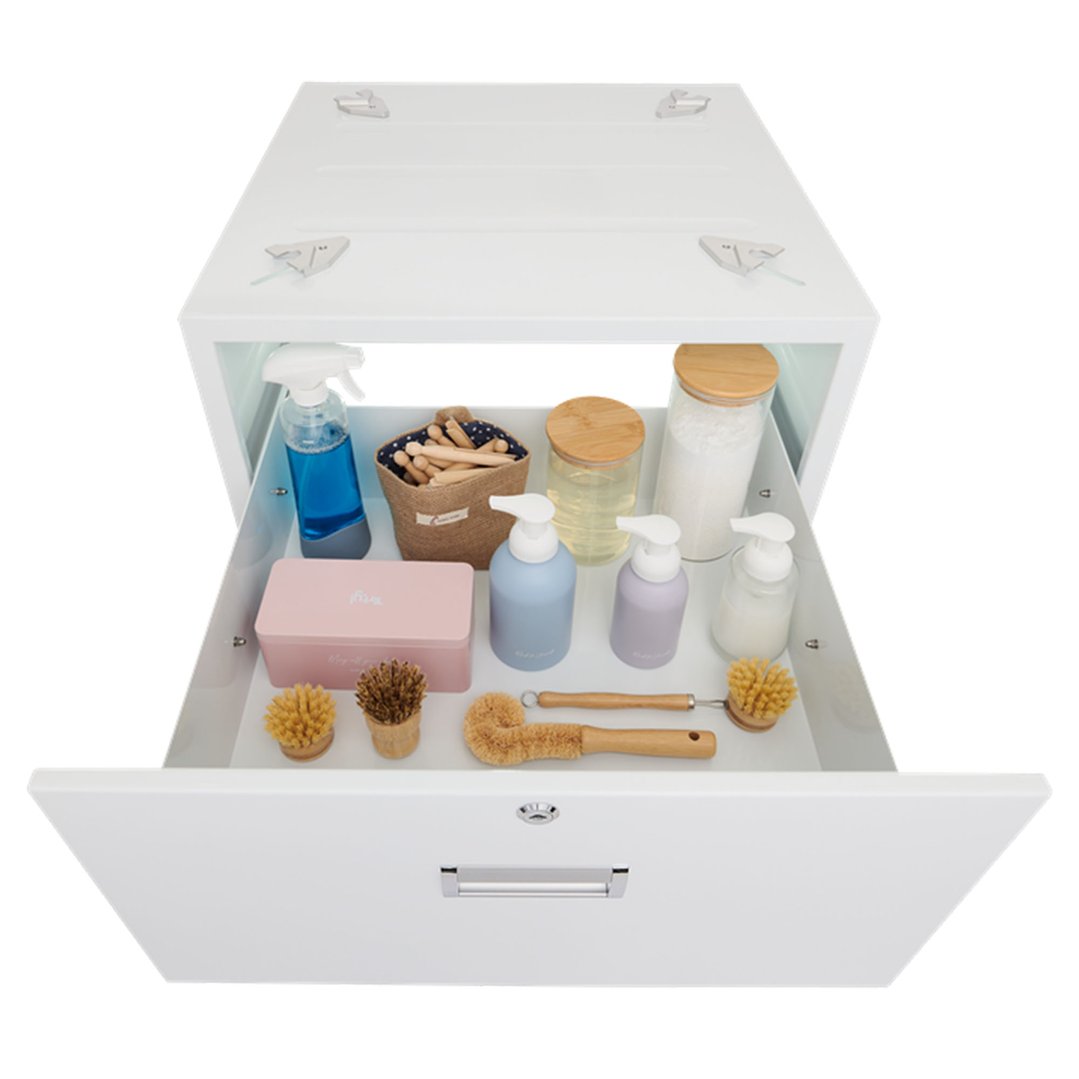 Open laundry pedestal drawer filled with cleaning supplies and brushes on a white background