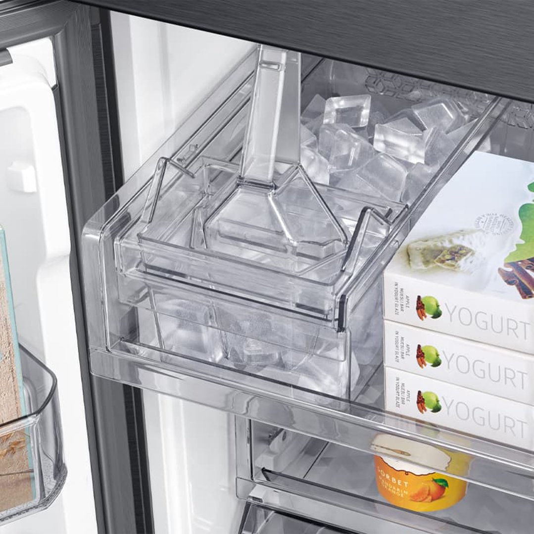 Close-up of the internal ice maker and frozen food items inside a refrigerator
