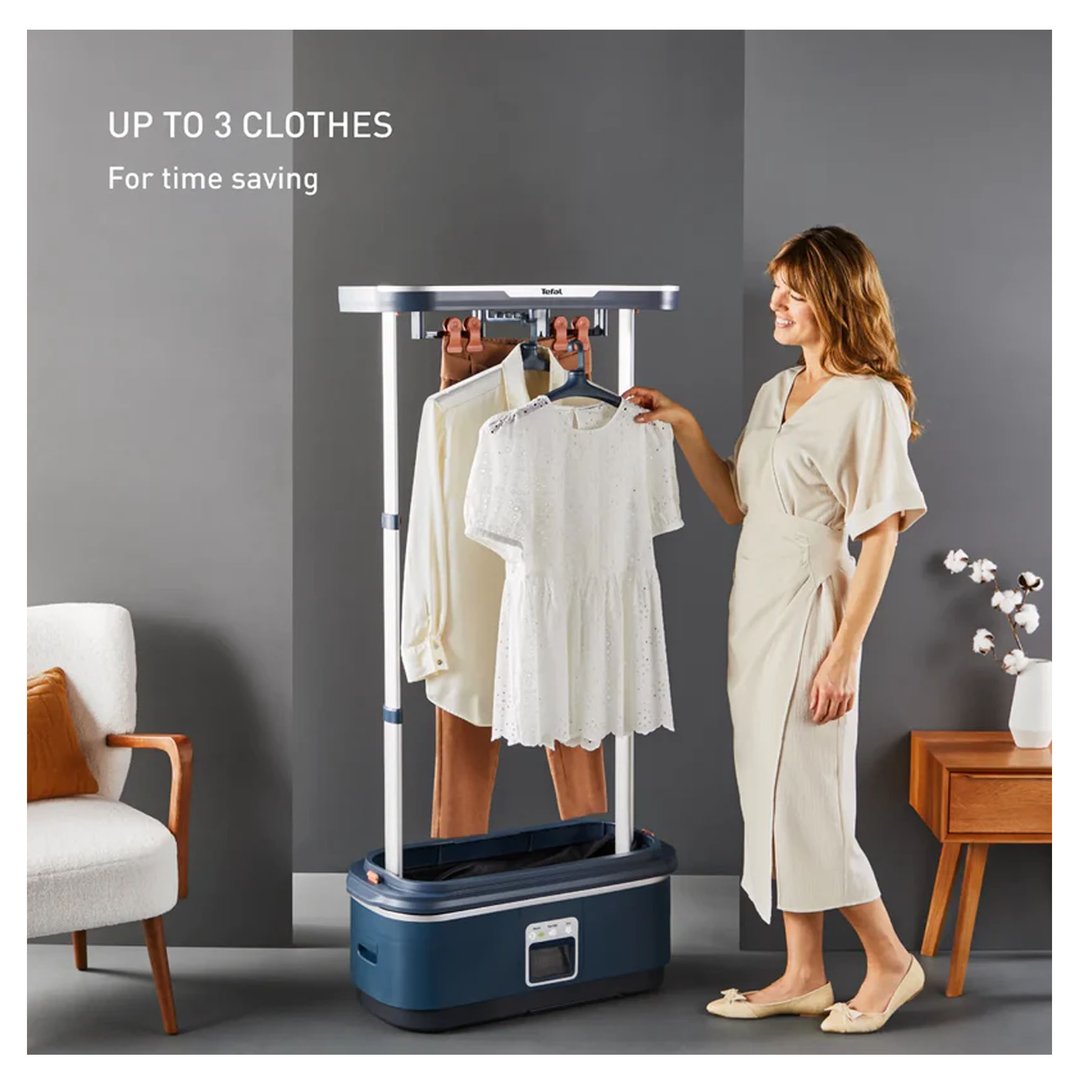 Woman hanging clothes on a Tefal garment steamer in a living room