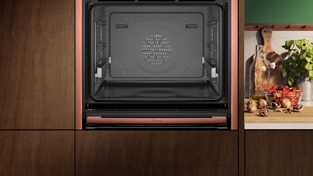 Built-in oven with open door in a kitchen with cooking ingredients on the counter