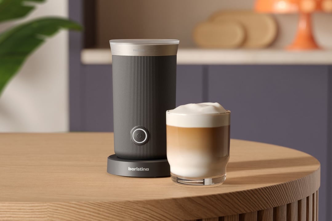 Philips Baristina Milk Frother and a glass of latte on a wooden table
