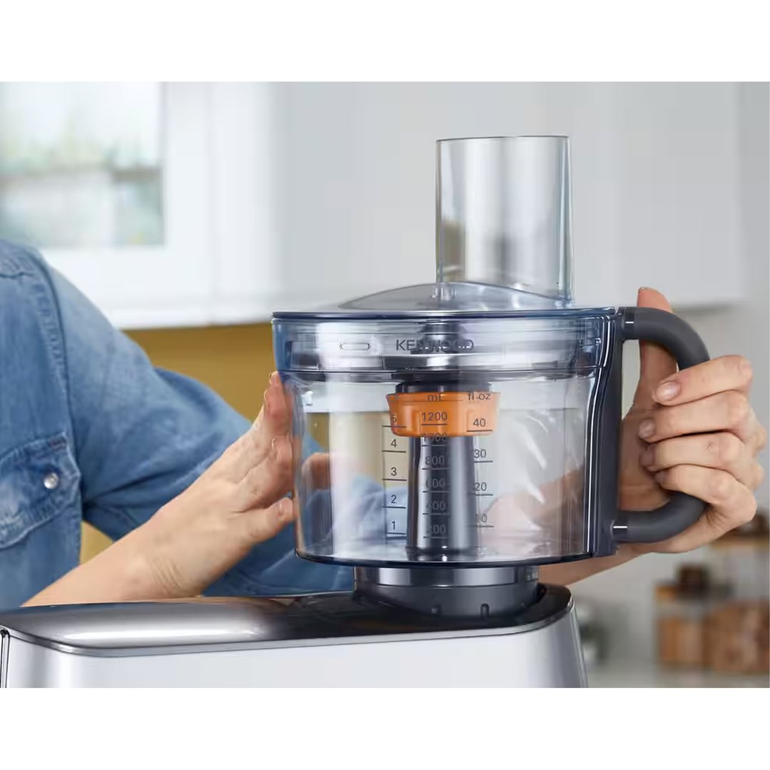 Person's hands holding a Kenwood Food Processor Attachment with measurements visible