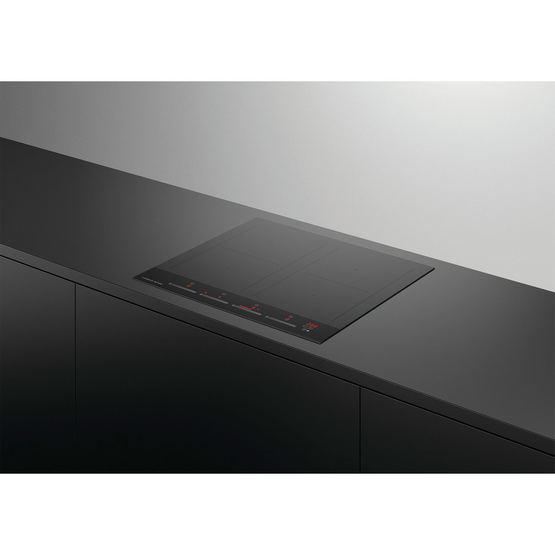 Induction cooktop built into a black kitchen counter with dark cabinetry