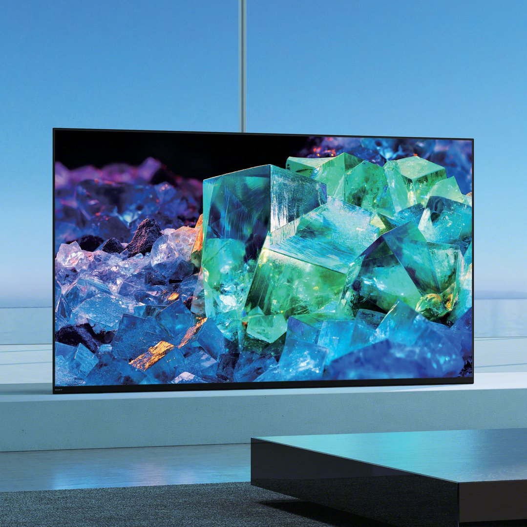 A Sony TV displaying colorful crystals, placed on a stand in a room