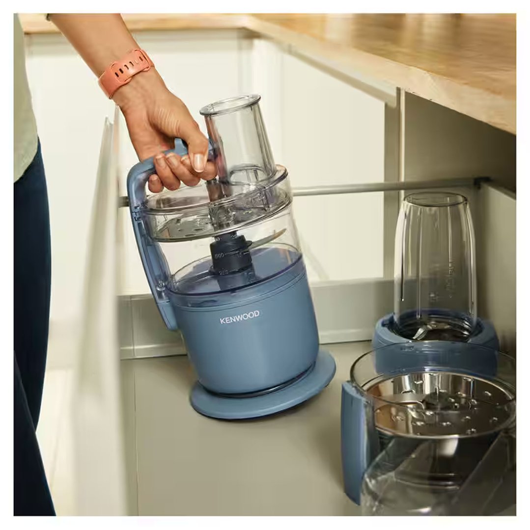 Hand placing a Kenwood food processor into a kitchen cabinet