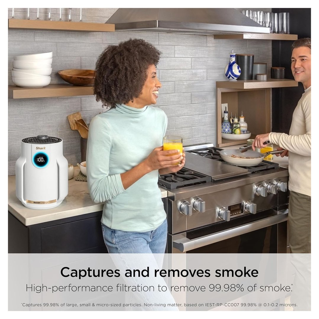 Man cooking on stove while woman holds drink next to air purifier