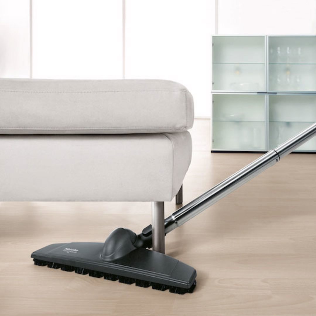 Vacuum cleaner parquet twister XL floorbrush cleaning under a light grey sofa