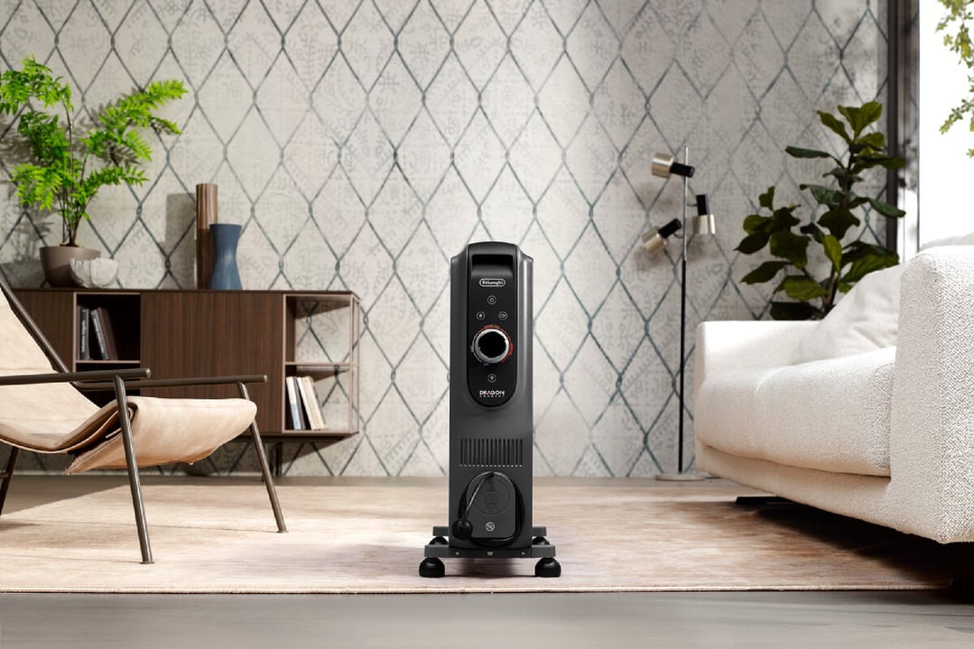 Black oil column heater on a rug in a living room setting